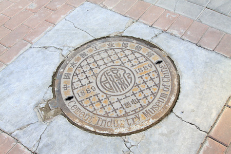 TANGSHAN CITY - NOVEMBER 18: Municipal manhole cover on the road, on november 18, 2014, Tangshan City, Hebei Province, Chinaのeditorial素材