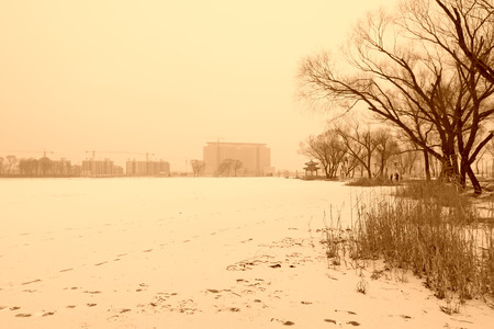 river and building landscape in a park after snow in winter, north chinaの写真素材