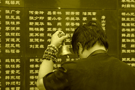 Tangshan City, July 28: A man shaking hand bell mourning their loved ones died in the earthquake, before the Tangshan Earthquake Memorial Wall on July 28, 2012,のeditorial素材