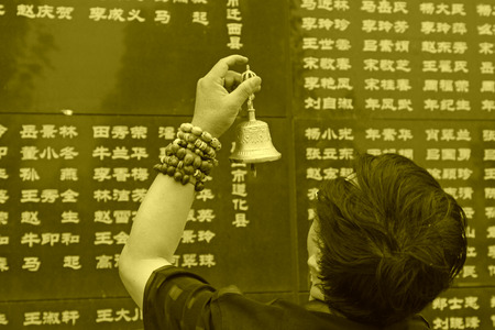 Tangshan City, July 28: A man shaking hand bell mourning their loved ones died in the earthquake, before the Tangshan Earthquake Memorial Wall on July 28, 2012, Tangshan City, Hebei Province, China.のeditorial素材