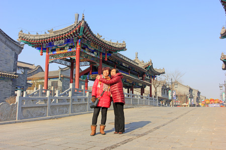 LUAN COUNTY - DECEMBER 14: two ladies dress in red standing across in the street, on december 14, Luan County, Hebei Province, Chinaのeditorial素材