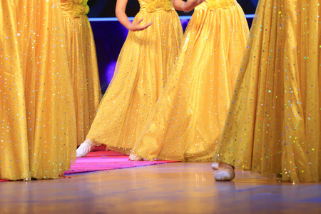 dancer with yellow dress on the stage, closeup of photoの写真素材
