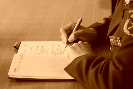chinese soldier hand taking notes, closeup of photoのeditorial素材
