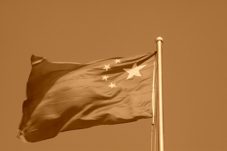 Chinese national flag in blue sky background, closeup of photoの写真素材