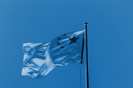 Chinese national flag in blue sky background, closeup of photoの写真素材