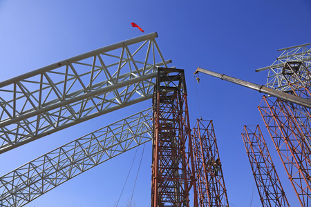 Truss girder and crane under blue sky