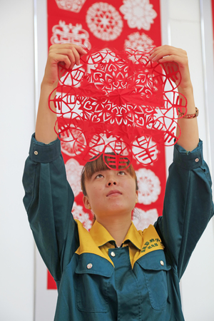 Luannan county - May 13: a girl watching paper-cut works, on May 13, 2016, Luannan county, hebei province, China.のeditorial素材