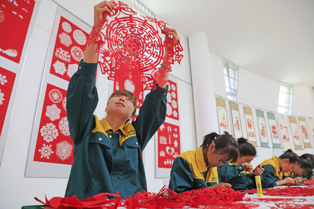 Luannan county - May 13: a girl watching paper-cut works, on May 13, 2016, Luannan county, hebei province, China.のeditorial素材