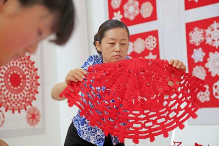 Luannan county - May 13: lady sorting out paper-cut works sorting out paper-cut works, on May 13, 2016, Luannan county, hebei province, China.のeditorial素材