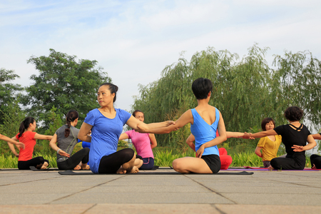 Tangshan - July 3: women doing yoga exercise in the park, July 3, 2016, tangshan city, hebei province, Chinaのeditorial素材