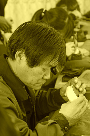 TANGSHAN CITY - NOVEMBER 18: Workers processing gold and silver handicrafts in a factory, on november 18, 2014, Tangshan City, Hebei Province, Chinaのeditorial素材