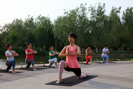 Luannan county - June 10, 2017: Several women doing yoga exercise in the park, luannan county, hebei province, Chinaのeditorial素材