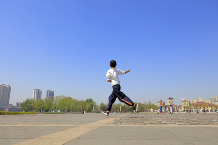 A Chinese girl flying a kite in the squareのeditorial素材