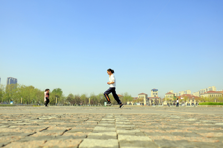 A Chinese girl flying a kite in the squareのeditorial素材