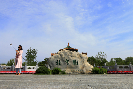 Tangshan City - May 15, 2016: a girl in self timer, Chinese ancient architecture, in a park, Tangshan City, Hebei, China

のeditorial素材