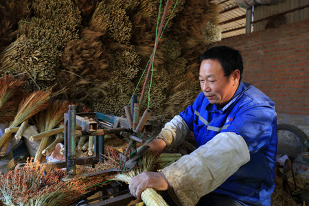 Luannan County - December 21, 2017: worker processing whisk broom in a hand workshop, Luannan County, Hebei Province, China. This is the most important traditional handicraft industry in the local area.

のeditorial素材