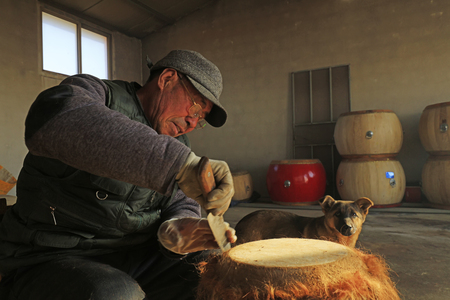 Luannan County - February 6, 2018: craftsman is working on the drum in workshops, Luannan, Hebei, Chinaのeditorial素材