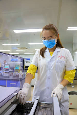 Luannan County - September 7, 2018: A female inspector is conducting a test analysis, Luannan County, Hebei Province, Chinaのeditorial素材