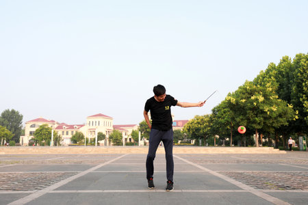 Luannan County, China-July 12, 2019: People wave Diabolo to exercise in parks, Luannan County, Hebei Province, China. Diabolo is one of the traditional Chinese folk fitness ways.のeditorial素材