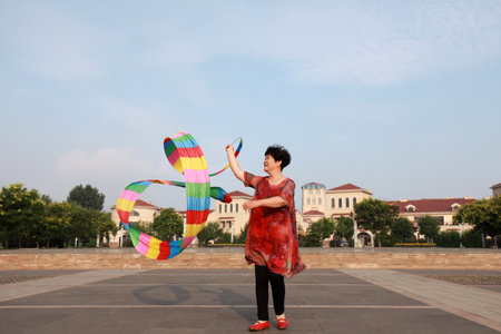 Luannan County, China-July 11, 2019: People wave ribbons to exercise in parks, Luannan County, Hebei Province, China. Nowadays, many Chinese people attach great importance to physical exercise.のeditorial素材