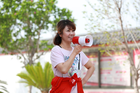 Luannan County, China-July 10, 2019: A fashionable lady speaks with a loudspeaker in her hand, Luannan County, Hebei Province, Chinaのeditorial素材