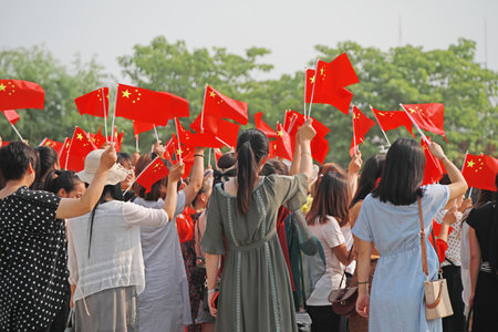 A group of people waving flags, their backsのeditorial素材