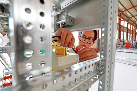 Luannan County, China-June 21, 2019: Technicians are assembling electrical equipment in a factory, Luannan County, Hebei Province, China.のeditorial素材