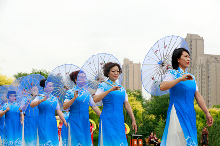 LUANNAN COUNTY, China-June 9, 2018: Women in cheongsam perform in the park, LUANNAN COUNTY, Hebei Province, Chinaのeditorial素材