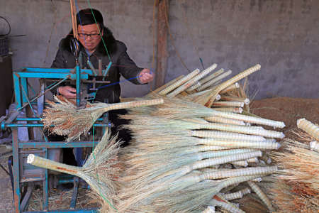 LUANNAN COUNTY, China-December 6, 2020: Workers handcraft big brooms in a workshop, LUANNAN COUNTY, Hebei Province, Chinaのeditorial素材