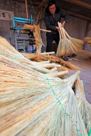 LUANNAN COUNTY, China-December 6, 2020: Workers handcraft big brooms in a workshop, LUANNAN COUNTY, Hebei Province, Chinaのeditorial素材