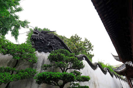 Shanghai, China-May 31, 2018: The sculpture of the dragon head is on the wall in Yu Garden, Shanghai, Chinaのeditorial素材