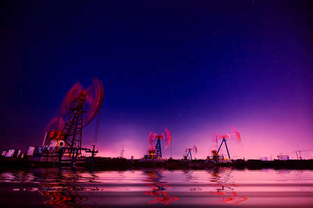 Oil pumping machinery in operation, crude oil extraction scene in the night, North Chinaの写真素材