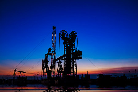 Oil pumping machinery in operation, crude oil extraction scene in the night, North Chinaの写真素材