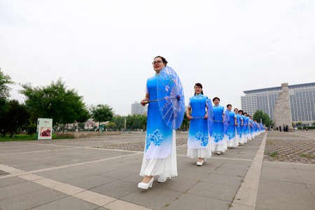LUANNAN COUNTY, China-June 9, 2018: Women in cheongsam perform in the park, LUANNAN COUNTY, Hebei Province, Chinaのeditorial素材