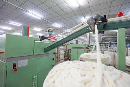 LUANNAN COUNTY, Hebei Province, China-March 18, 2020: The female worker is busy on the production line in a spinning factory.のeditorial素材