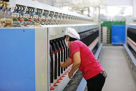 The female worker is busy on the production line in a spinning factory.のeditorial素材