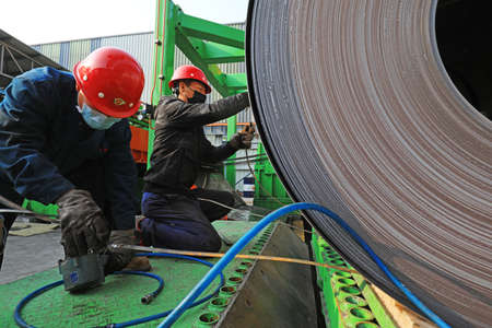 LUANNAN COUNTY, Hebei Province, China-March 25, 2020: Workers are busy on the strip production line in a factory.のeditorial素材