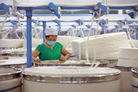 LUANNAN COUNTY, Hebei Province, China-March 18, 2020: The female worker is busy on the production line in a spinning factory.のeditorial素材