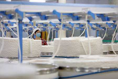 LUANNAN COUNTY, Hebei Province, China-March 18, 2020: The female worker is busy on the production line in a spinning factory.のeditorial素材