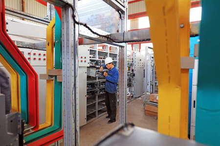LUANNAN COUNTY, Hebei Province, China-April 15, 2019: The workers are installing the power compensation cabinet in the workshop.のeditorial素材