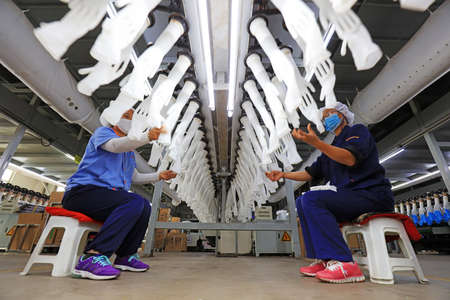 LUANNAN COUNTY, China-November 6, 2018: Female workers work on medical grade nitrile gloves production line, LUANNAN COUNTY, Hebei Province, Chinaのeditorial素材