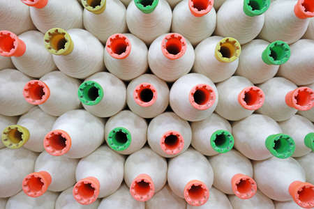 The colored cotton yarn is piled up in the factoryの写真素材