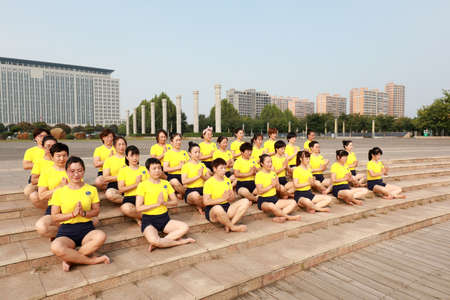 LUANNAN COUNTY, Hebei Province, China-September 26, 2020: Women practice yoga on the lawn in the parkのeditorial素材