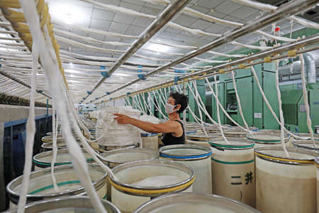 LUANNAN COUNTY, Hebei Province, China-July 17, 2020: The workers are busy on the production line in a spinning factoryのeditorial素材