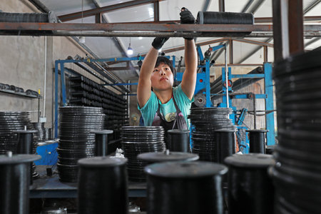 LUANNAN COUNTY, Hebei Province, China-August 20, 2020: Workers operate mechanical textile fishing nets in a net farmのeditorial素材
