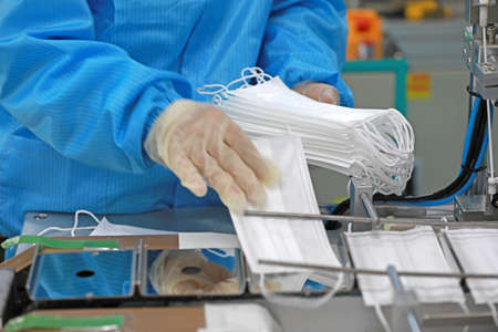 Workers are busy on the production line in a Medical mask factory.