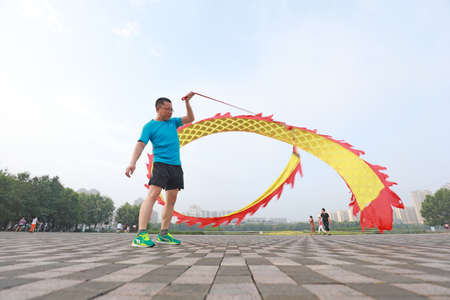LUANNAN COUNTY, Hebei Province, China-August 4, 2020: People shake colored silk to keep fit in the parkのeditorial素材