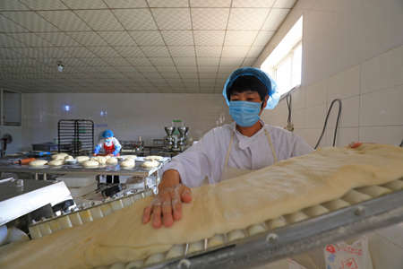 LUANNAN COUNTY, Hebei Province, China-September 27, 2020: Workers on the moon cake production line work hard in the food processing plantのeditorial素材