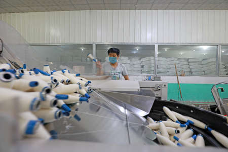 LUANNAN COUNTY, Hebei Province, China-July 17, 2020: The workers are busy on the production line in a spinning factoryのeditorial素材