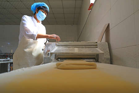 LUANNAN COUNTY, Hebei Province, China-September 27, 2020: Workers on the moon cake production line work hard in the food processing plantのeditorial素材